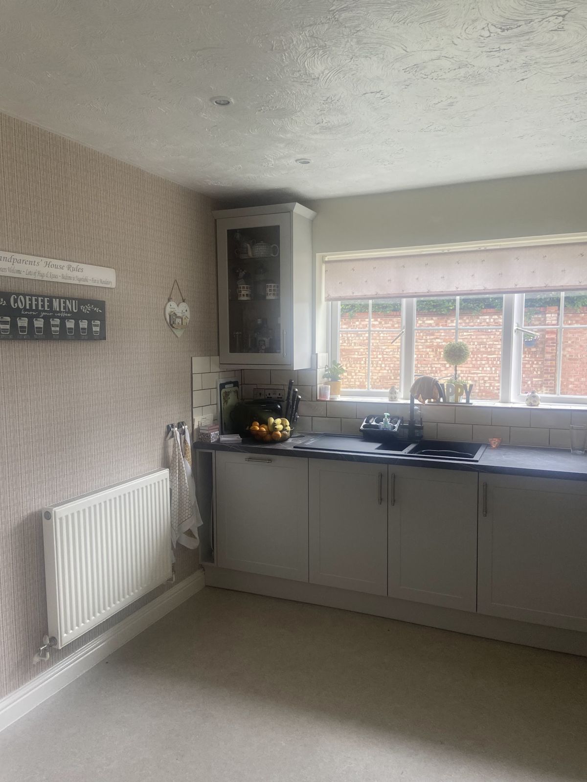 A full run of light grey base units under the window