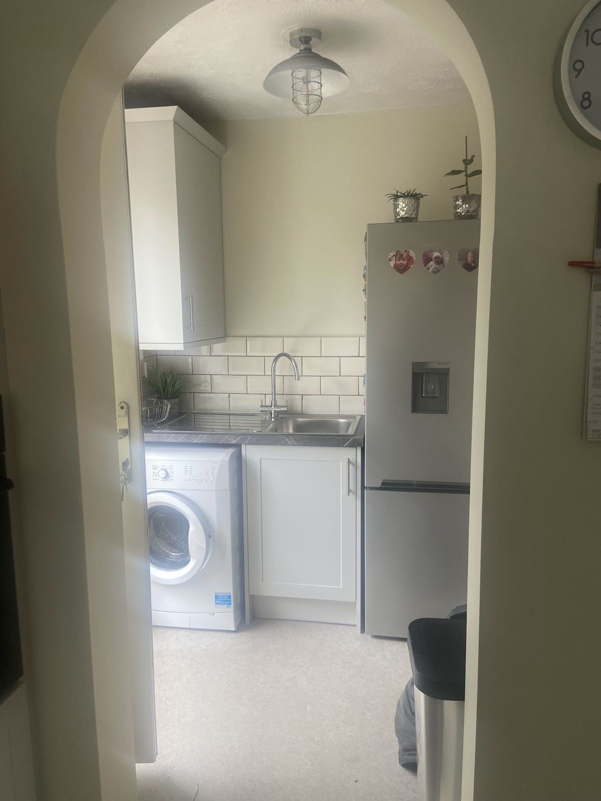 The utility room through an arch, with washing machine and fridge freezer